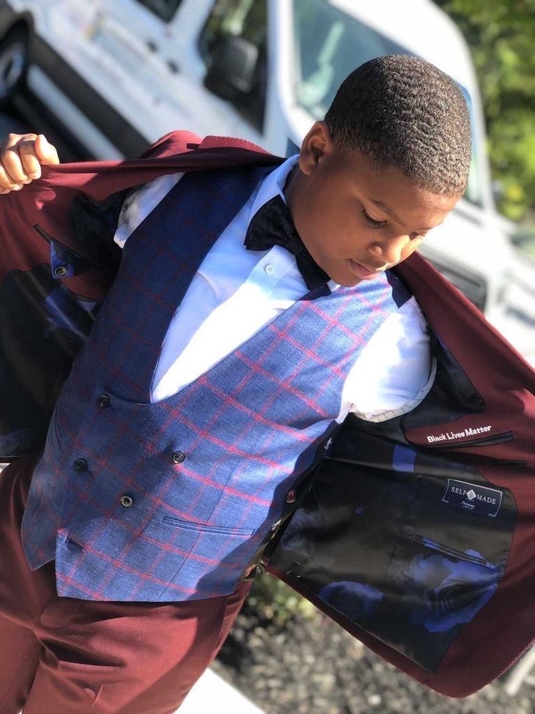 Student showing the lining of a checked suit jacket