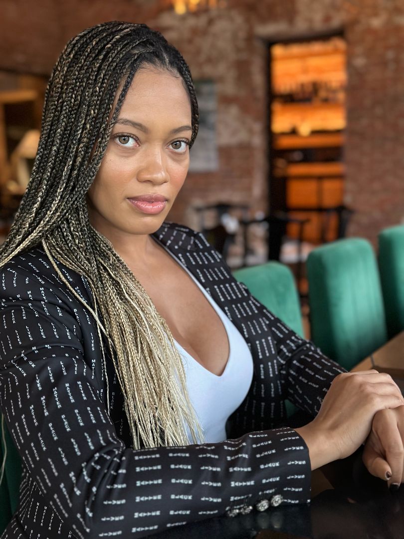 Person wearing a dark patterned jacket with a white top