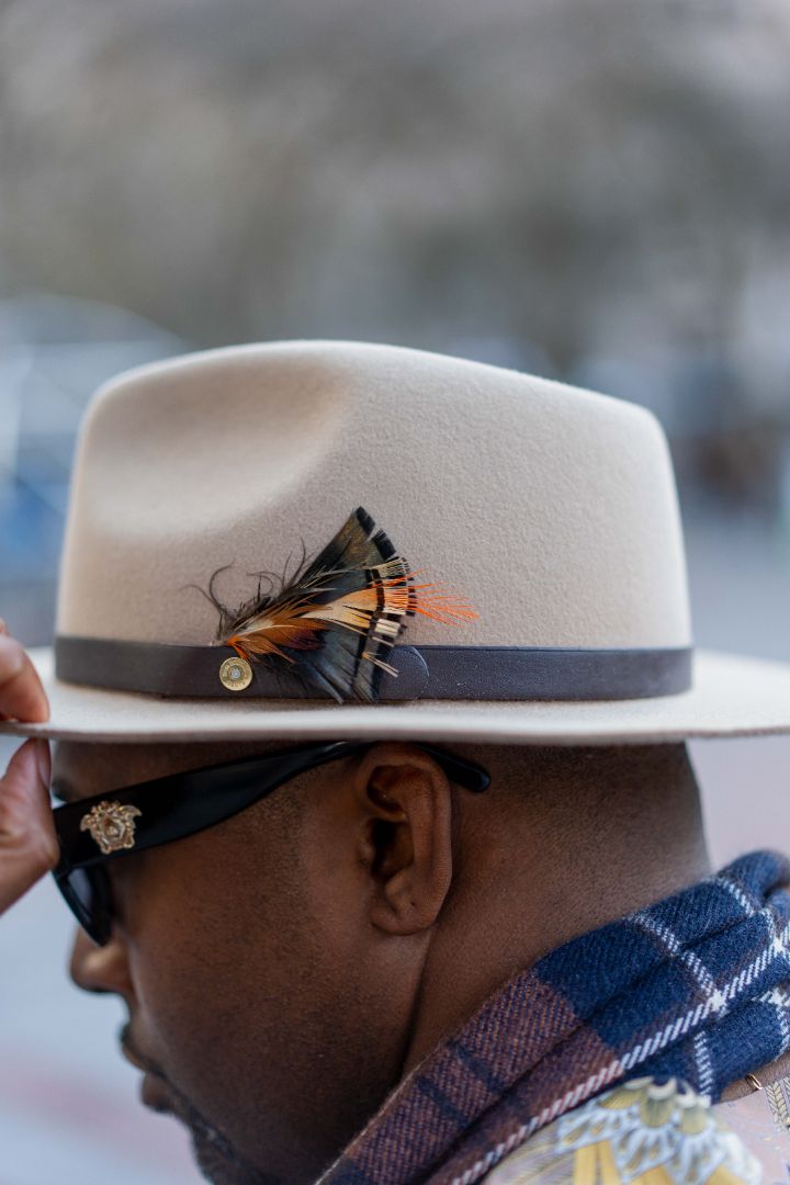 Close-up of a light-colored fedora worn with a checked jacket