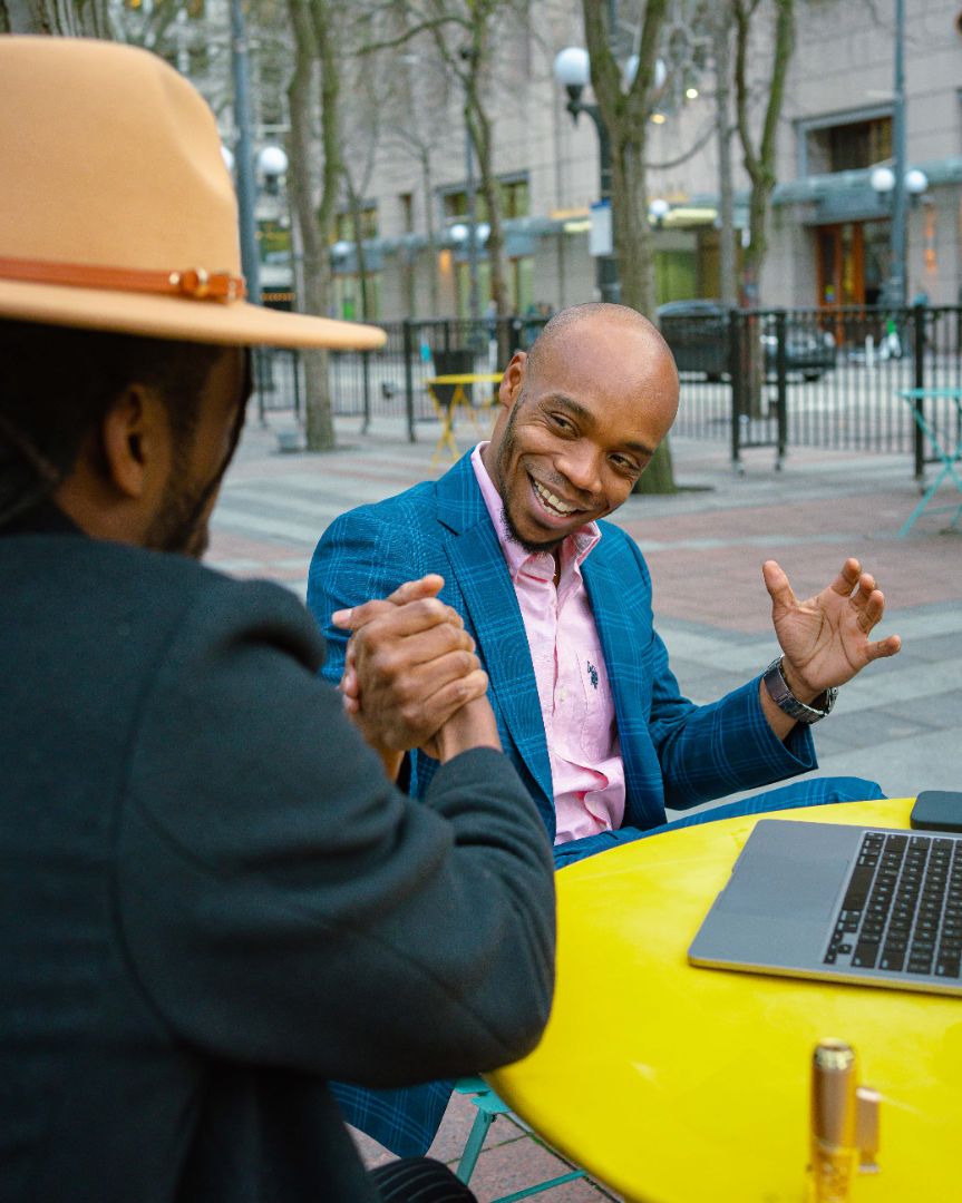 Client in a blue suit discussing clothing at a table